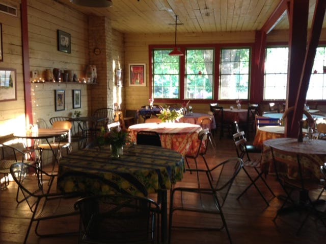 Tables and chairs inside the author's sunlit and inviting small business.