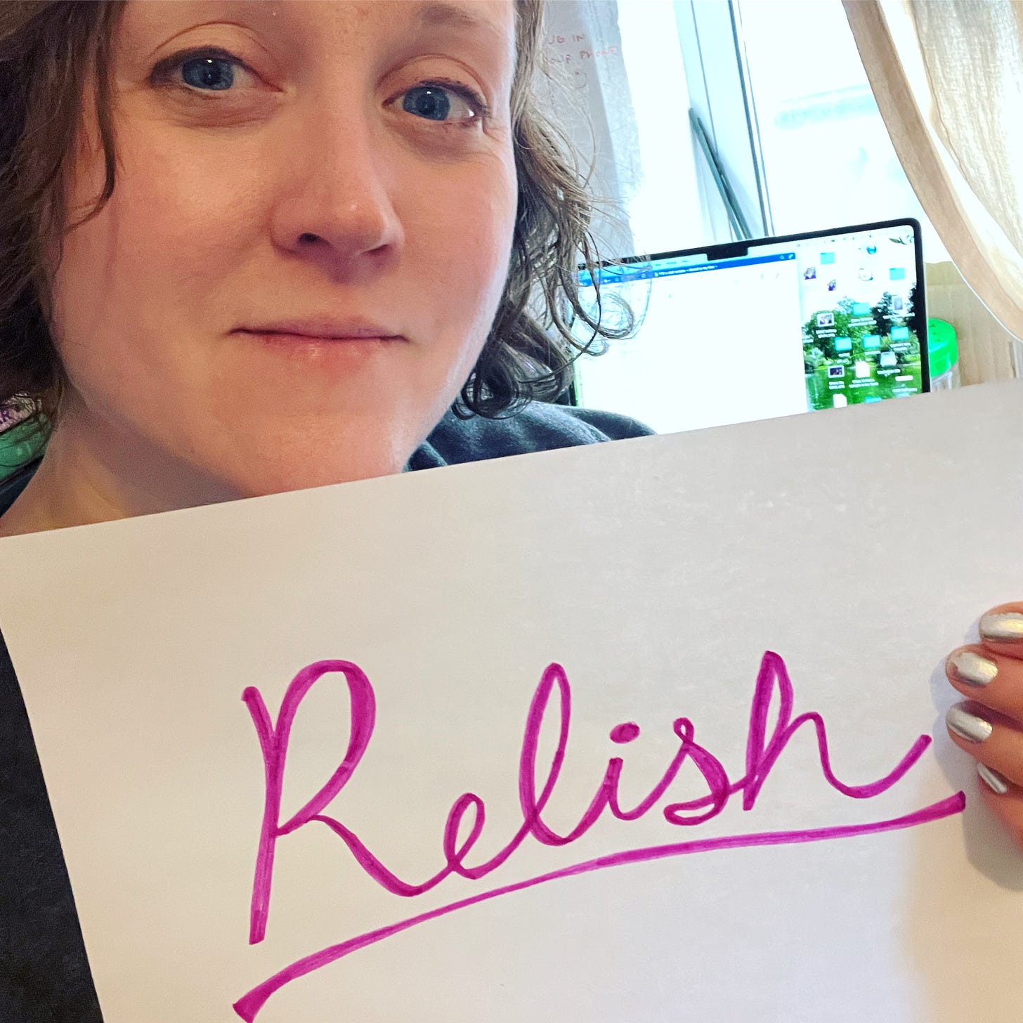 me holding a hand-written sign reading "relish" in purple cursive