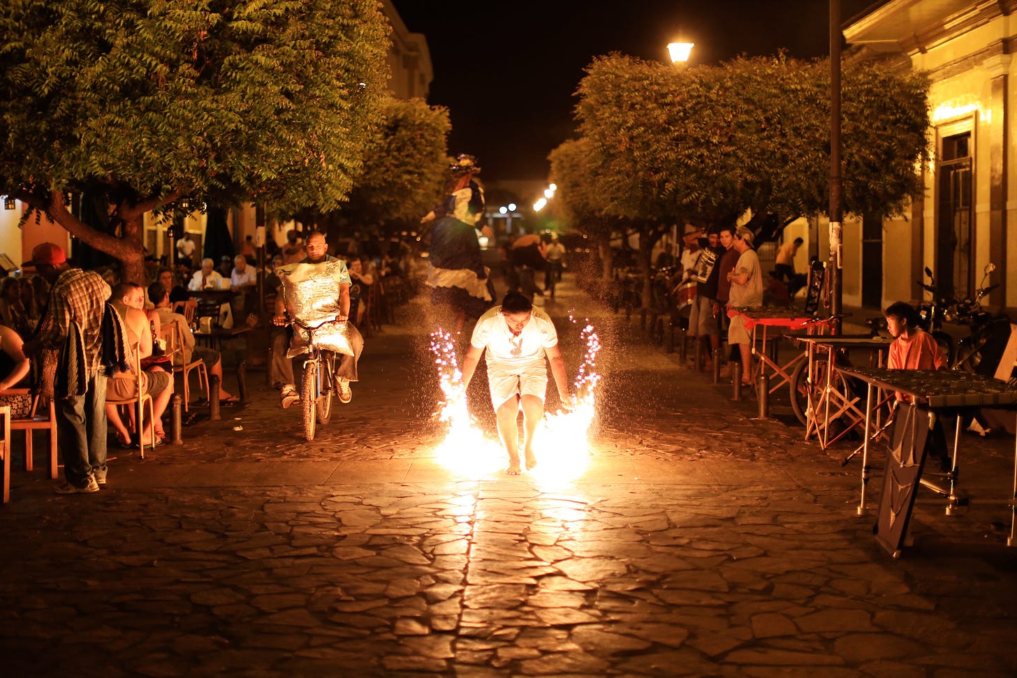 Man in Granada, Nicaragua walking down a street with sparklers in his hands