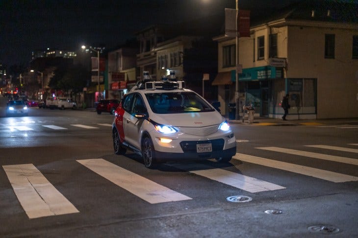 Cruise robotaxi crossing crosswalk at night