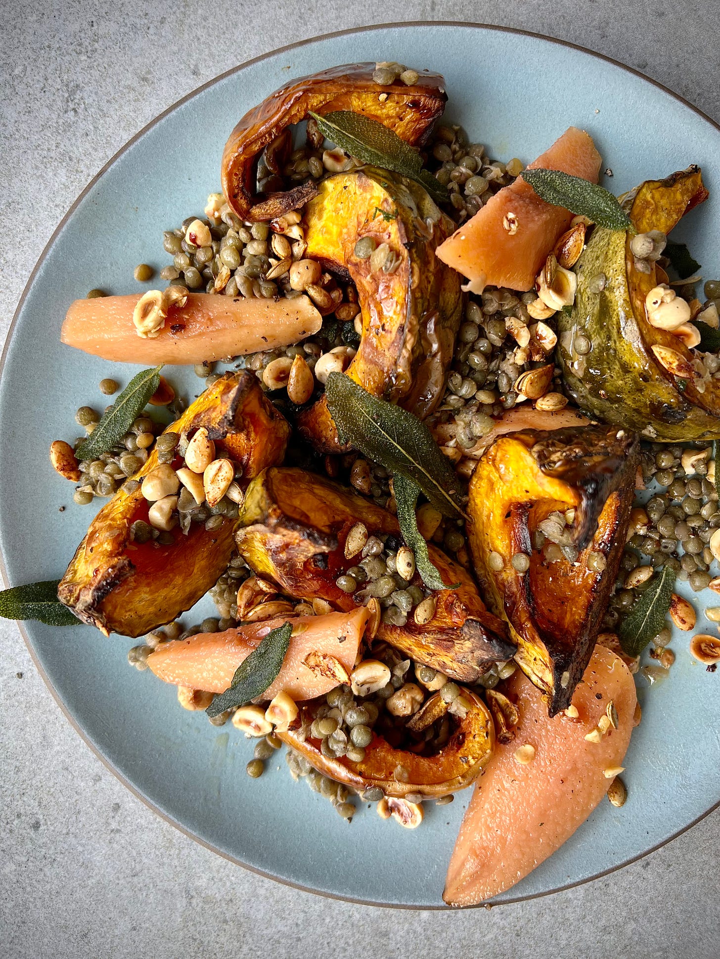 Plate of Roast pumpkin and puy lentils with pickled quince, sage and hazelnuts