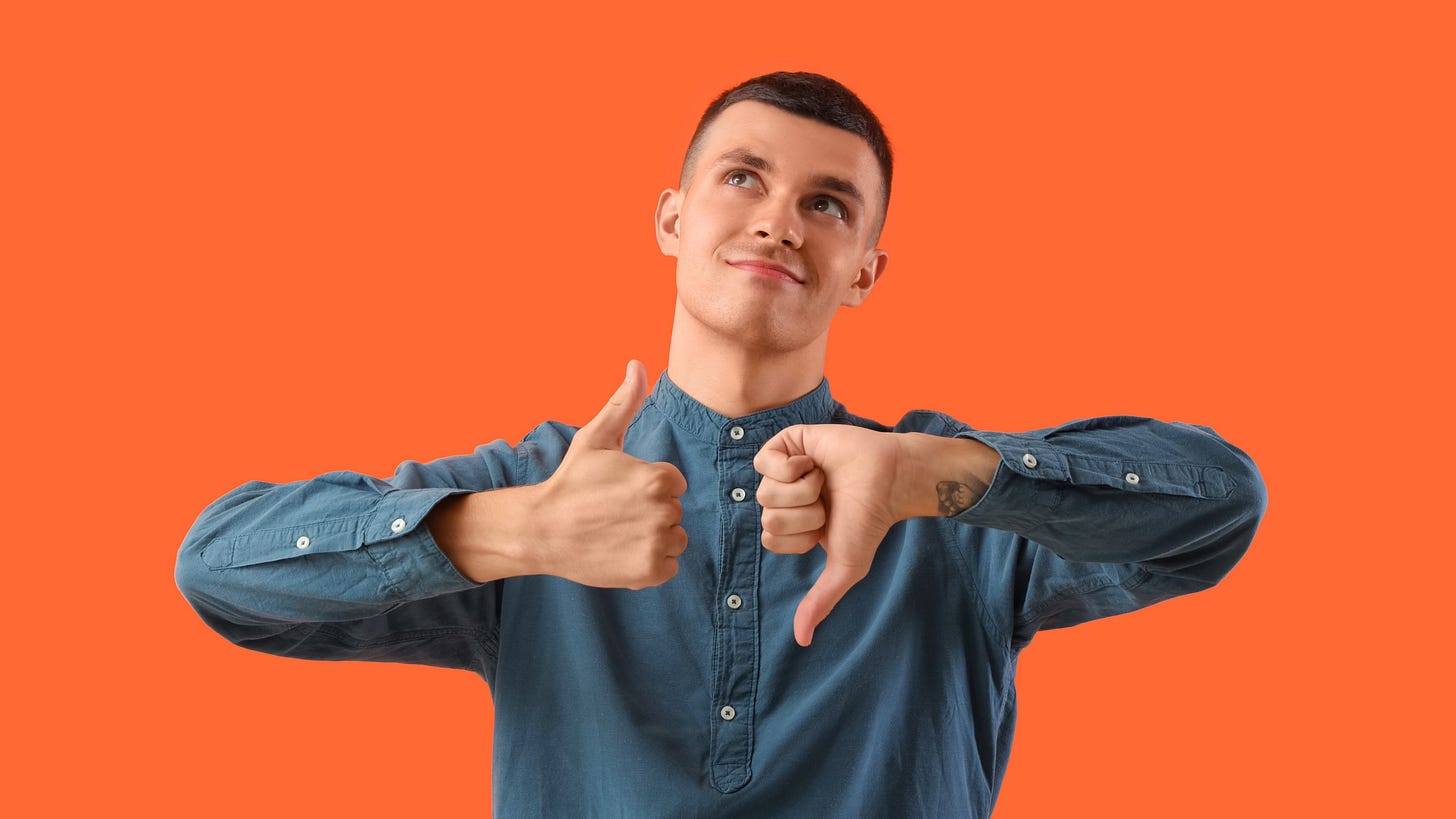 A young man in a blue shirt giving a thumbs-up with one hand and a thumbs-down with the other, looking thoughtful against an orange background.