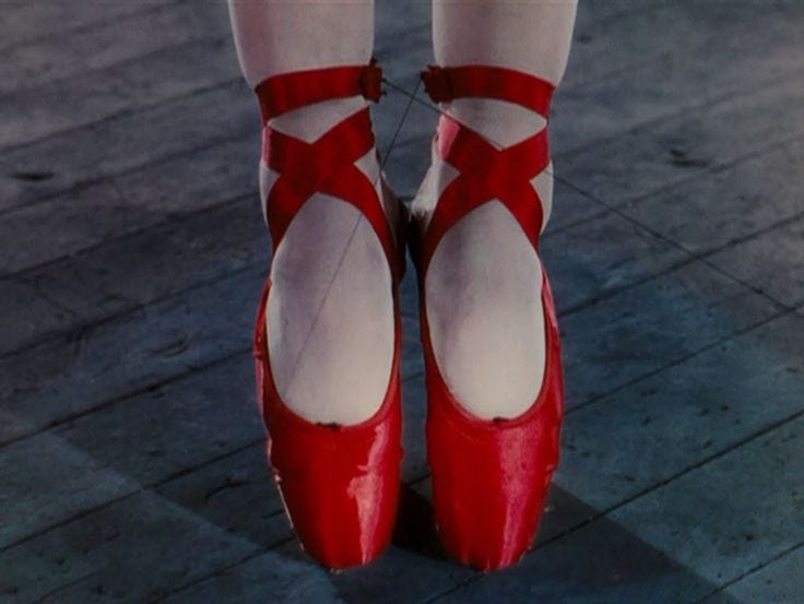 Scena del film in cui sono inquadrati i piedi della protagonista mentre è sulle punte e indossa le scarpette rosse.