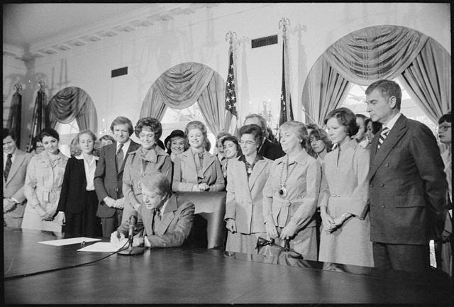 President Jimmy Carter signs the Extension of Equal Rights Amendment (ERA) Ratification on Oct. 20, 1978, while First Lady Rosalynn Carter (second from right) watches over. (Photo: United States National Archives and Records Administration)