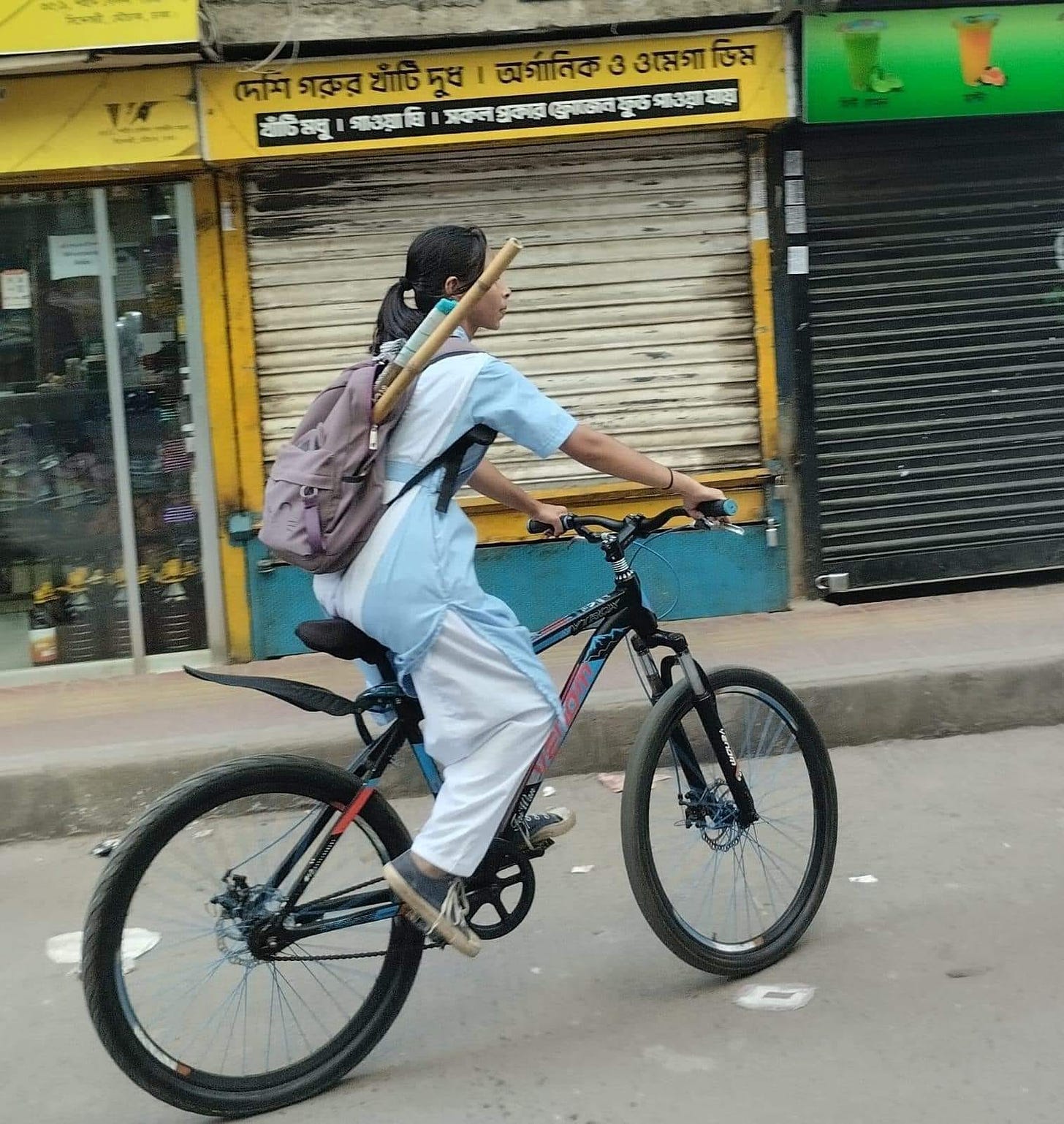 May be an image of 1 person, scooter, bicycle and street