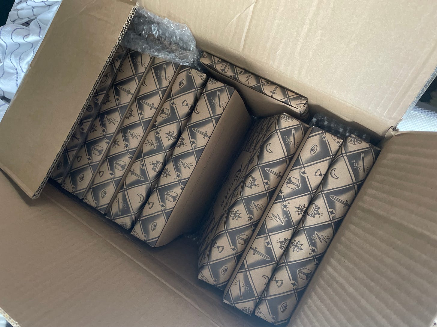 A cardboard box full of paper-wrapped copies of Koriko.