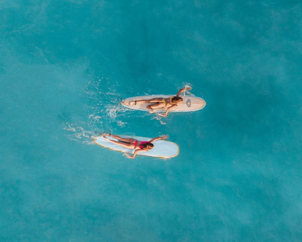 Two women enjoy surfing
