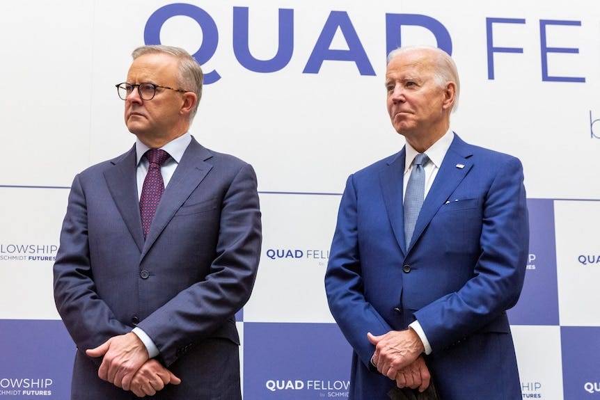 Anthony Albanese et Joe Biden se tiennent côte à côte devant la signalisation de l'événement Quad.