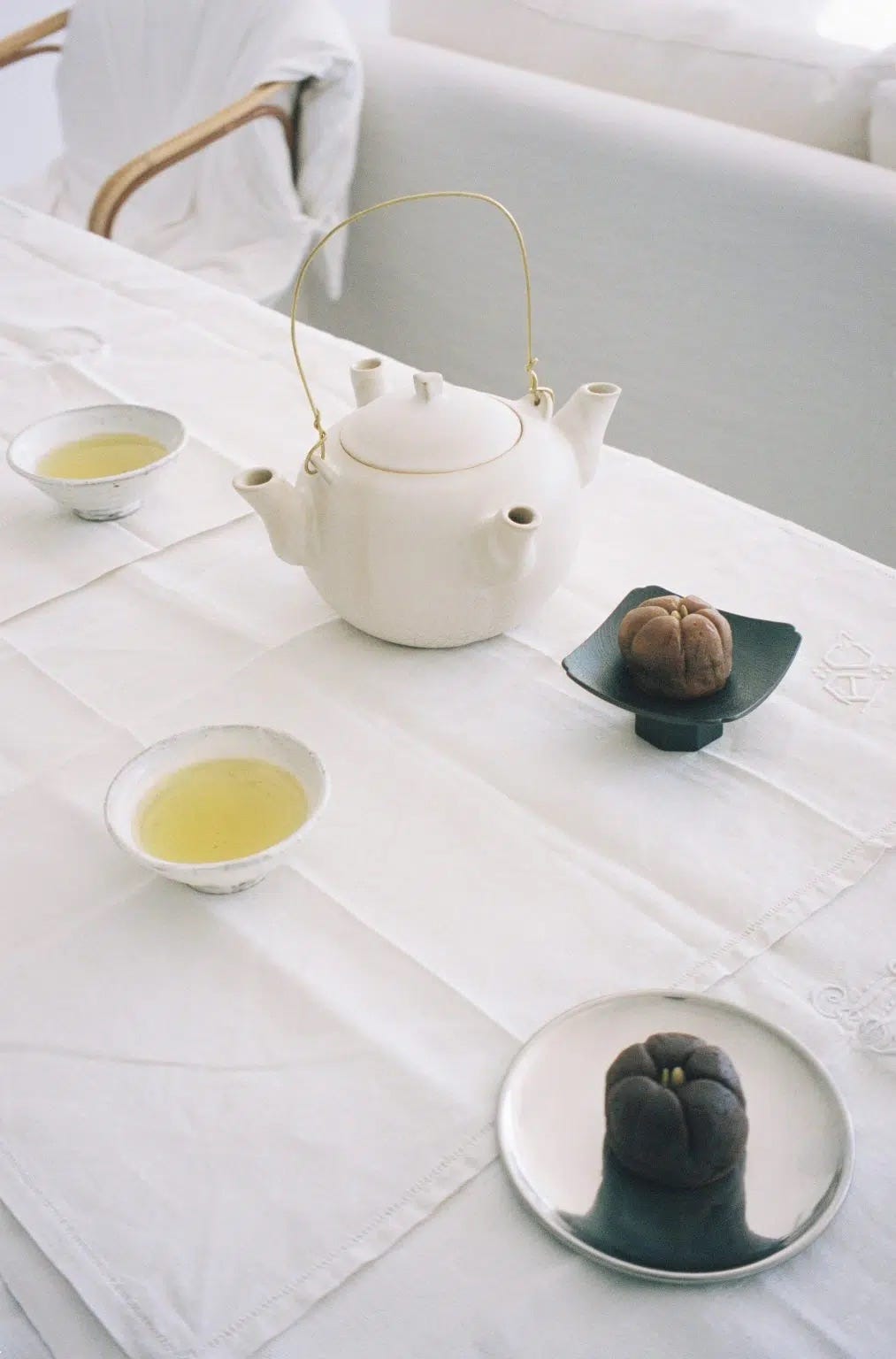 Dora Daar I to We teapot on a linen-covered dining table