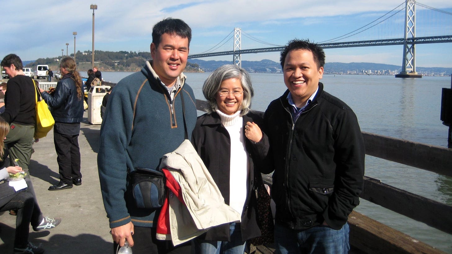 Photo of three people of Asian descent in front of the waterfront in San Francisco.