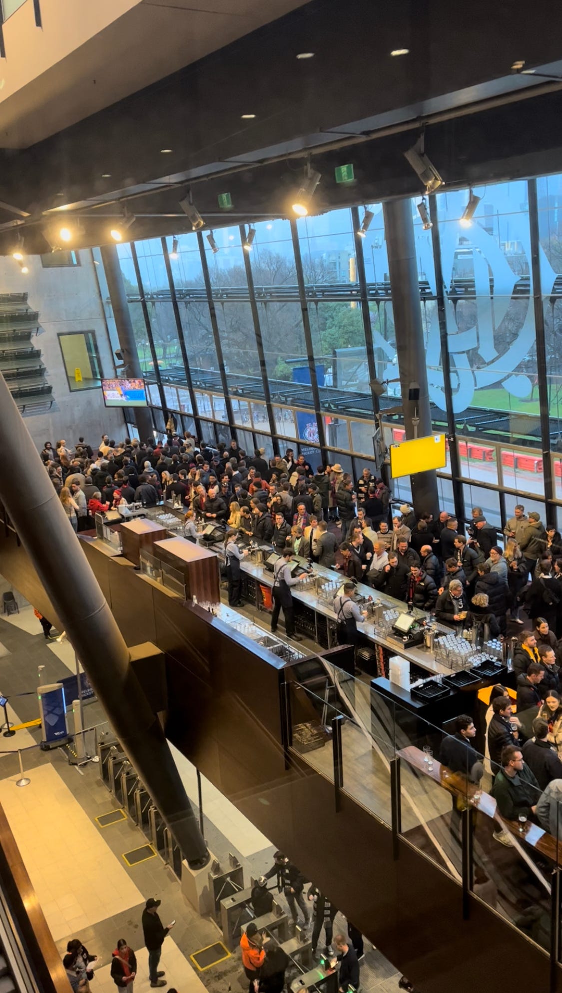 A photograph showing an overhead view of a packed MCC bar at the MCG full of people who showed up to watch the Matildas game on TV.