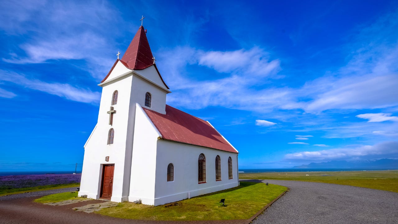 A white church building under a blue sky.