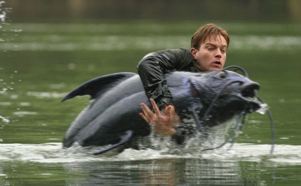 From Big Fish: Ewan McGregor struggles to hold on to a large catfish while standing in a river.