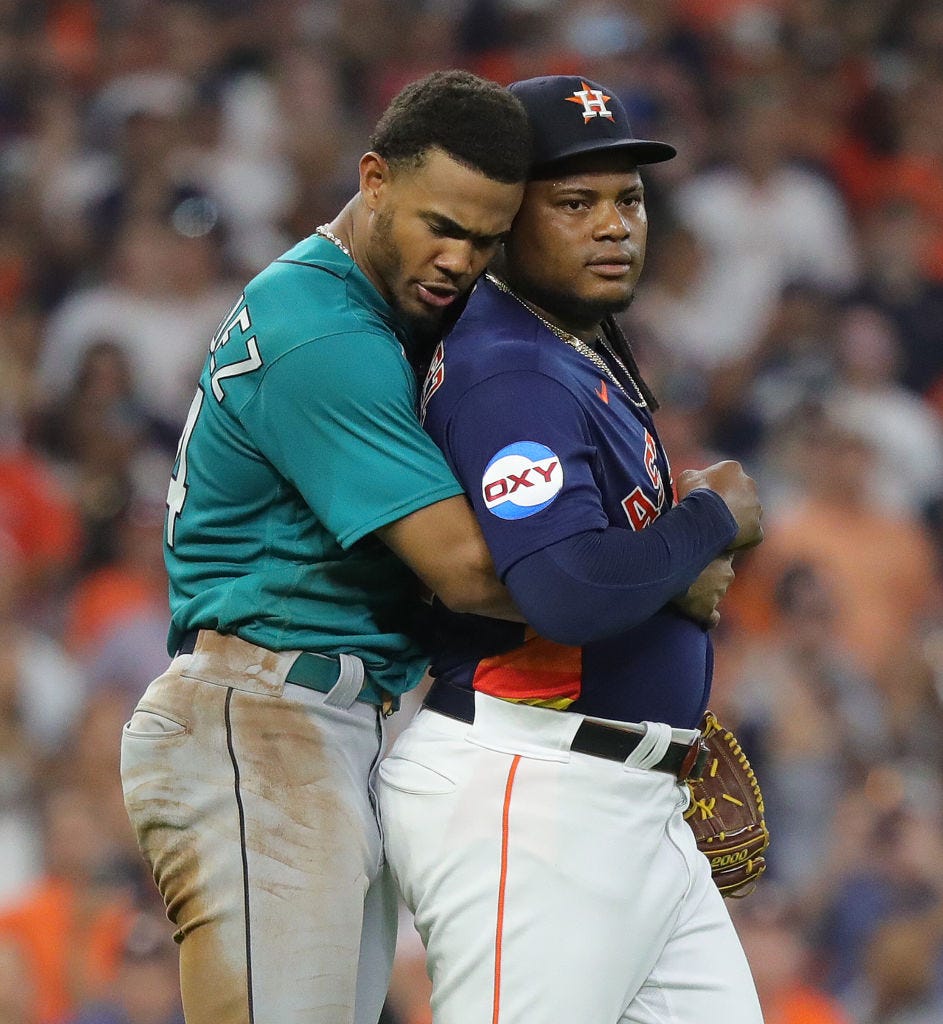 HOUSTON, TEXAS - AUGUST 19: Framber Valdez #59 of the Houston Astros is restrained by Julio Rodriguez #44 of the Seattle Mariners after the both benches cleared after Valdez hit Jose Caballero #76 with a pitch in the fifth inning at Minute Maid Park on August 19, 2023 in Houston, Texas. (Photo by Bob Levey/Getty Images)