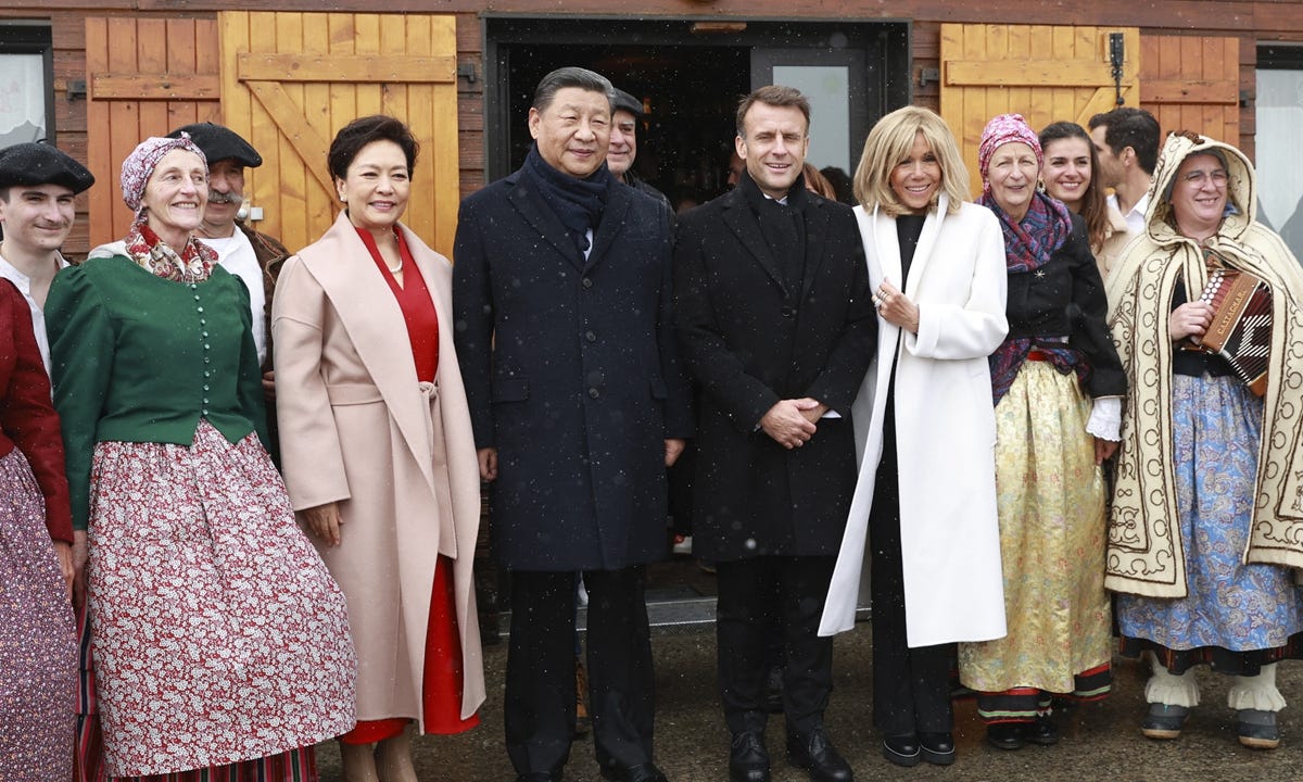 Chinese President Xi Jinping and French President Emmanuel Macron together with their wives, Peng Liyuan and Brigitte Macron, pose for a group picture with local folklore dancers at the Tourmalet pass, in the Pyrenees mountains, on May 7, 2024. Photo: AFP