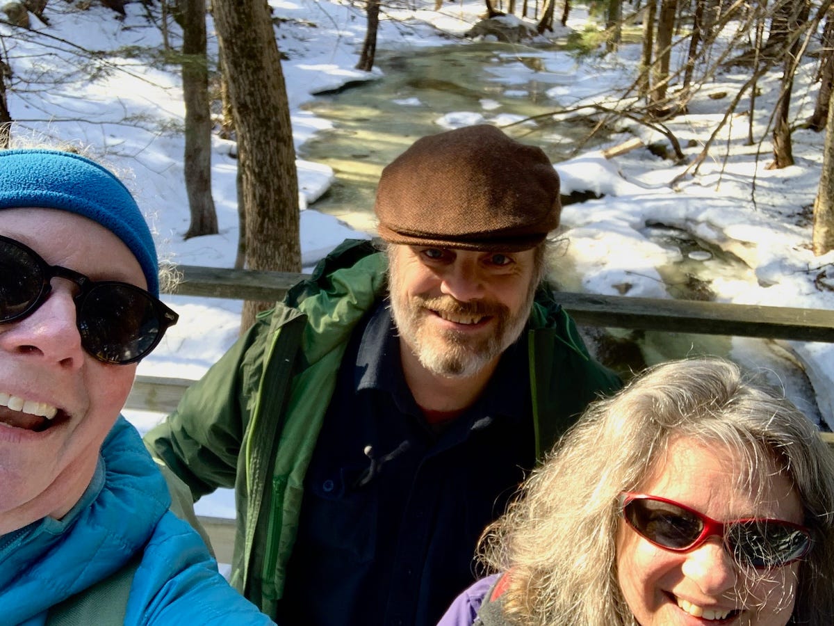 three-person selfie in a snowy forest