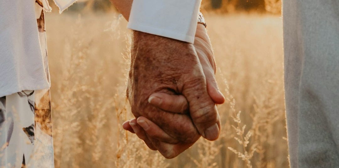 a close up of two people holding hands