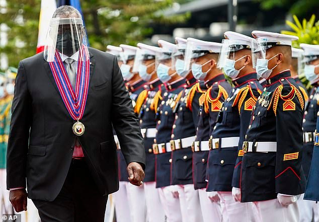 Pictured: United States Defense Secretary Lloyd Austin - seen left wearing a visor and face mask as protection again Covid-19 - views the military honor guard at Camp Aguinaldo military camp in Quezon City, Metro Manila, Philippines Friday, July 30, during a diplomatic mission to the country