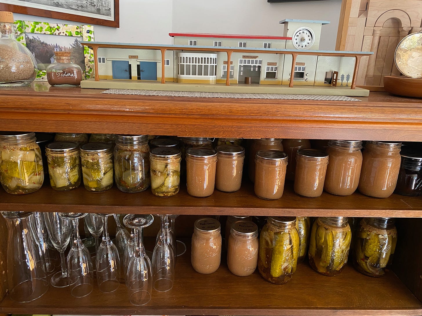 Jars of canned produce on wooden shelves.