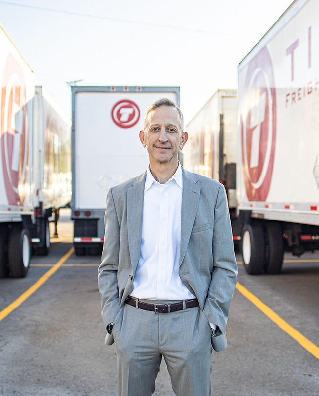 Keith Wilson standing in front of his trucks at TITAN Frieght Systems.