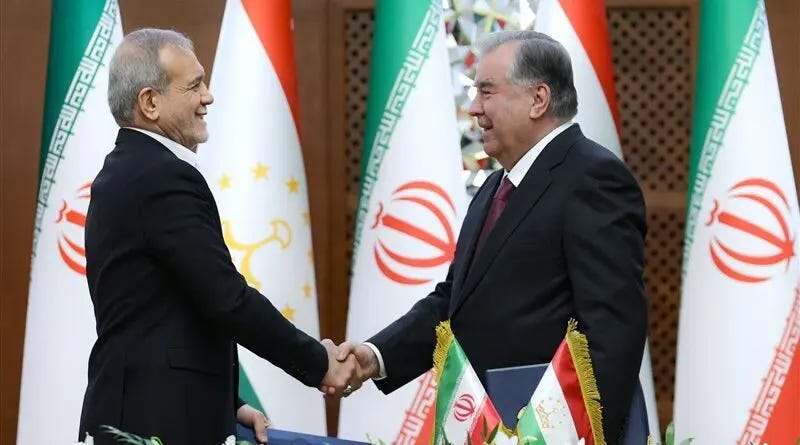 Two men shaking hands in front of flags

Description automatically generated