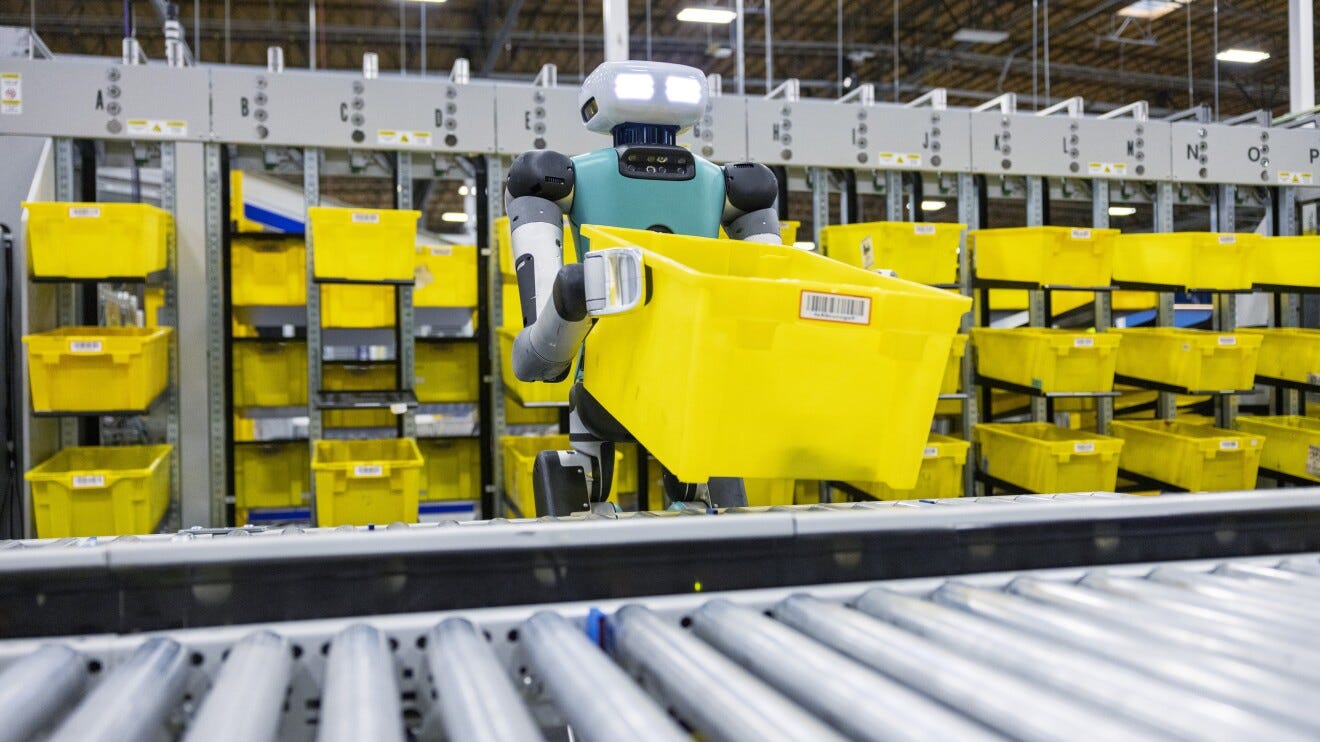 An image of the bi-pedal robot, Digit, working alongside an Amazon employee