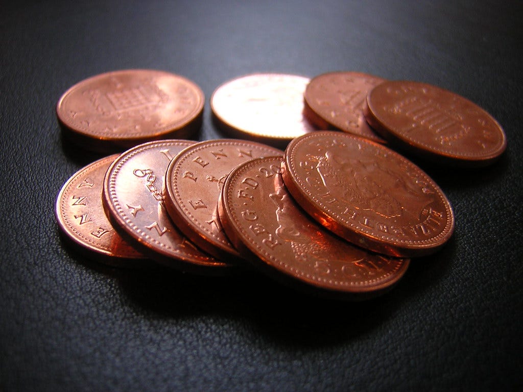 pile of copper penny coins on a black background