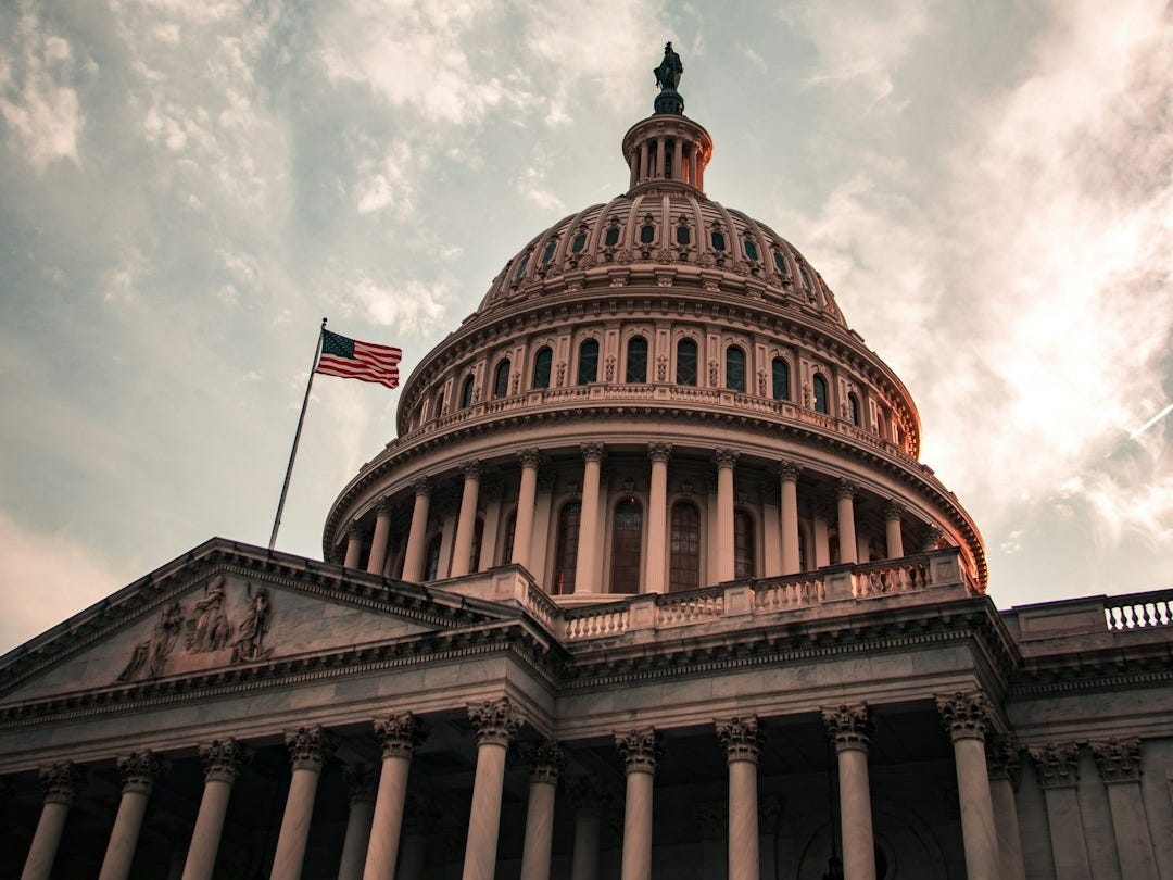 the dome of the u s capitol building under a cloudy sky