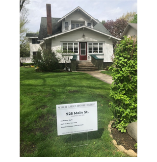 A house with a sign in front of it

Description automatically generated