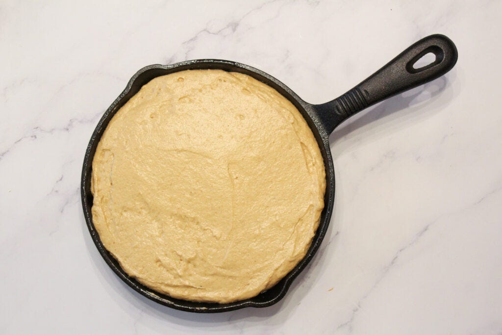 Upsidedown cake batter prepared in cast iron pan ready to be baked.