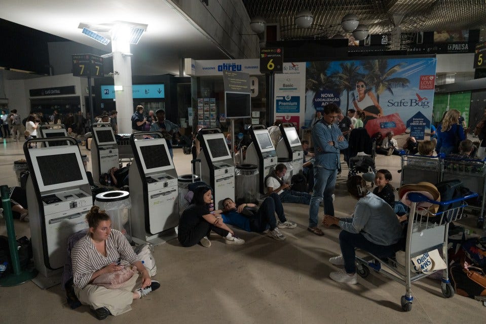 Passengers sitting on the floor of an airport during a power outage.