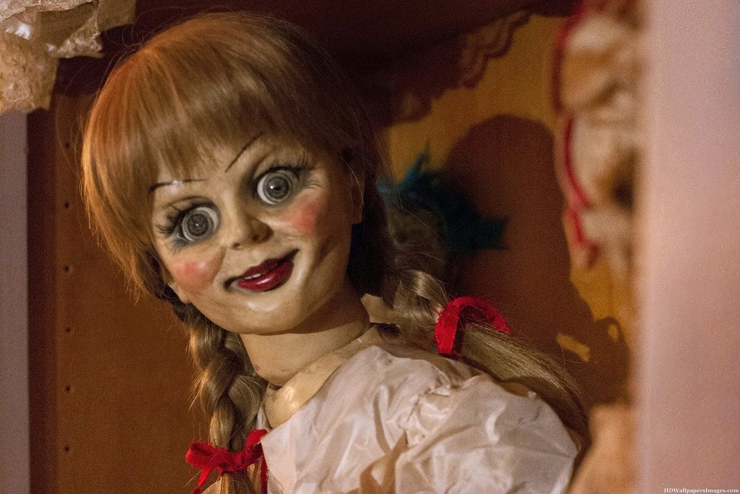 Foto di Annabelle, la bambola indemoniata del film. Ha capelli rossi raccolti in due trecce e una faccia spaventosa