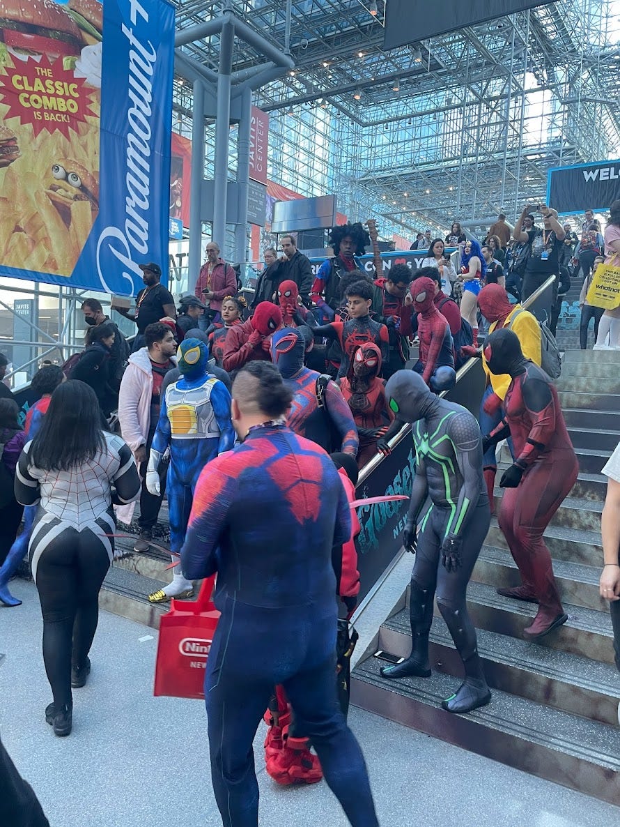 A group of Spiderman and variants cosplayers congregating on some steps in the Javits Center