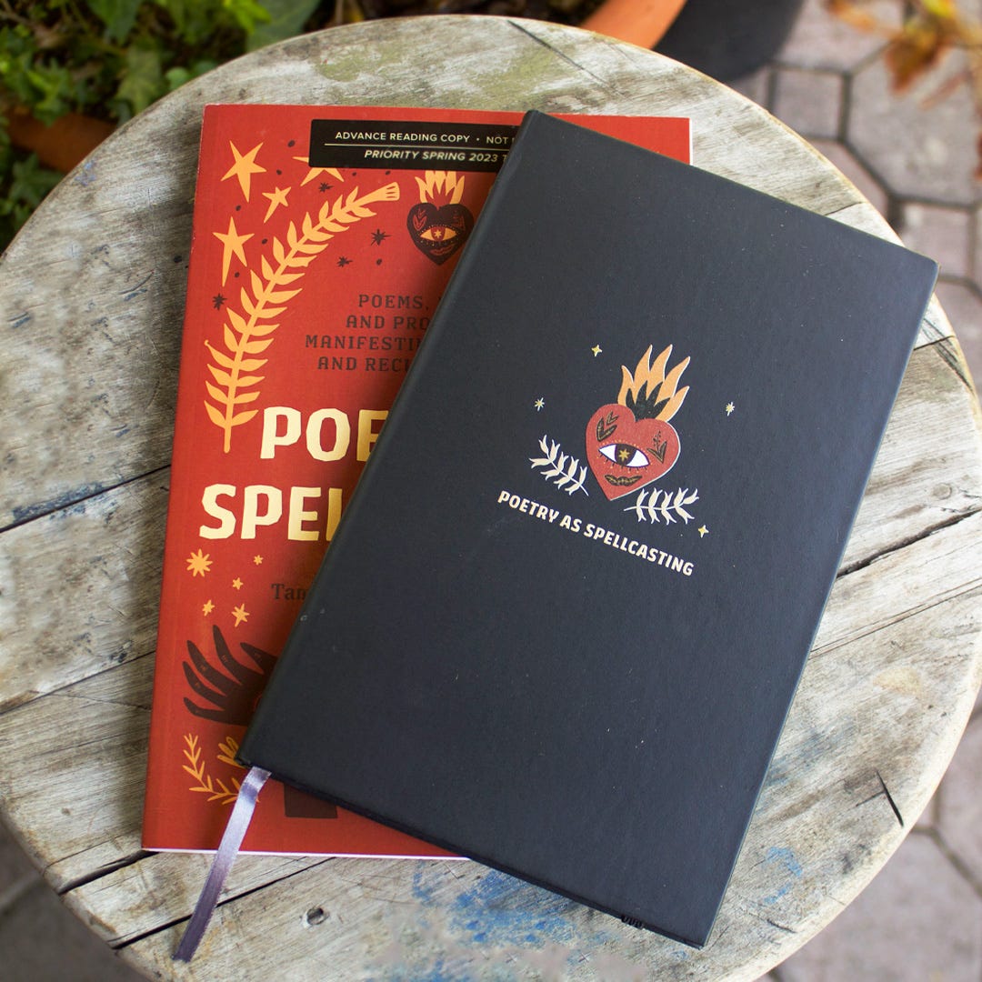 Image description: A black notebook with a design that includes a heart with an eye and flames and the text “Poetry as Spellcasting” on top of an advance reading copy of Poetry as Spellcasting on a wooden stool.