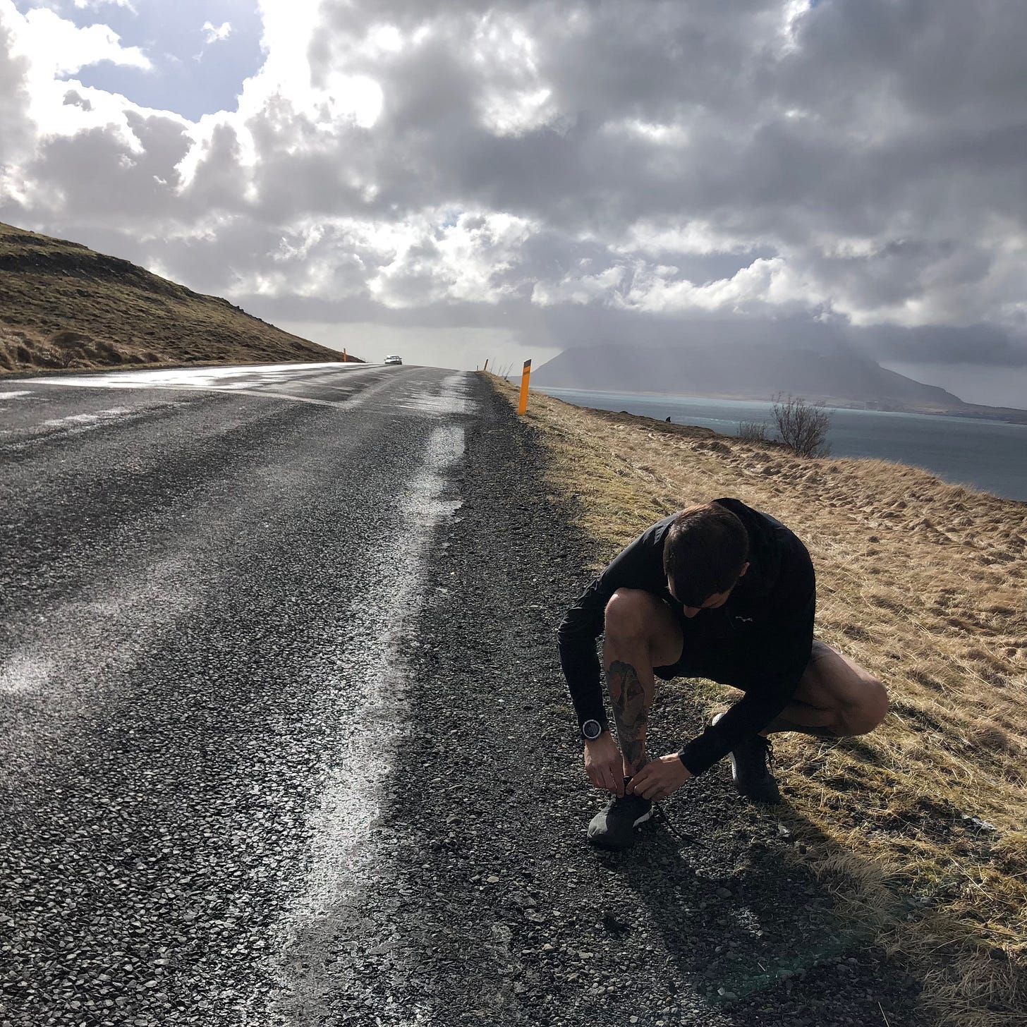 The author lacing up his shoes on a long road in Iceland