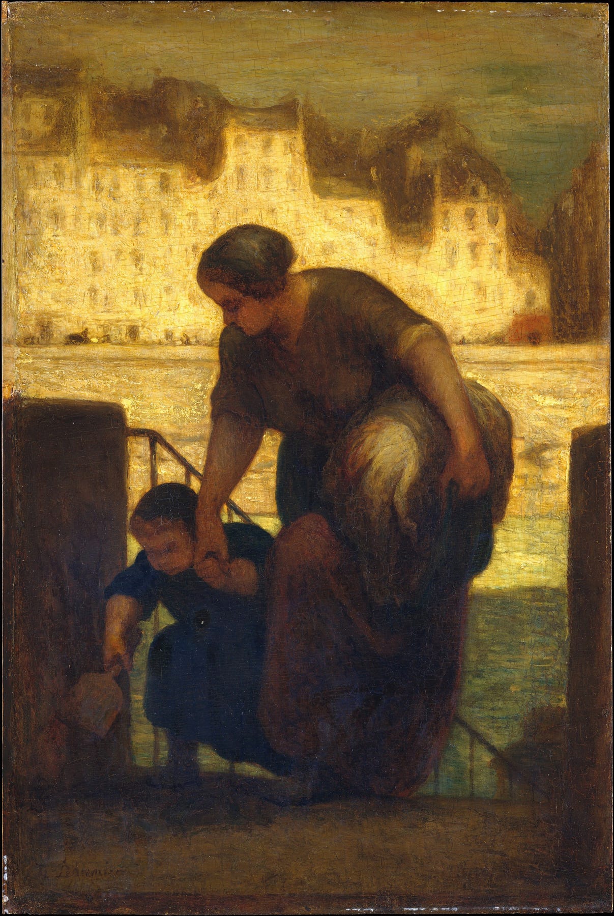 A women helping a young boy up the stairs while holding laundry