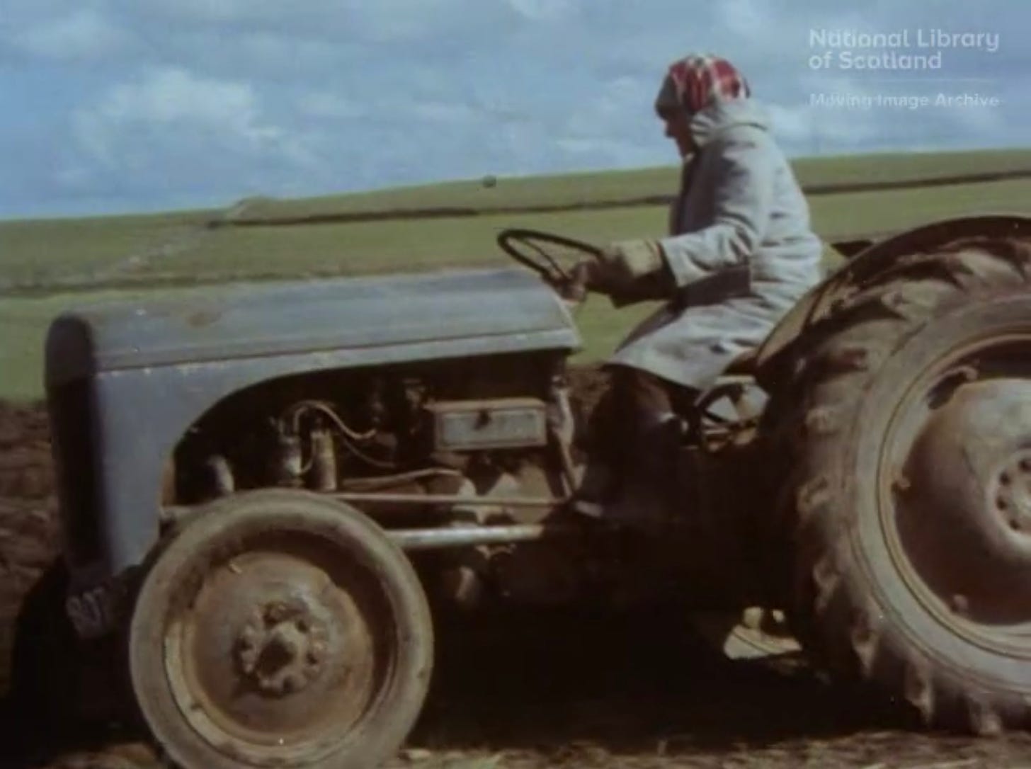 Cover image for Land Makar - A woman in the 1970s on top of a tractor as she works the land.