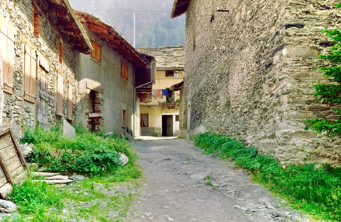 A dirt road between stone buildings

AI-generated content may be incorrect.