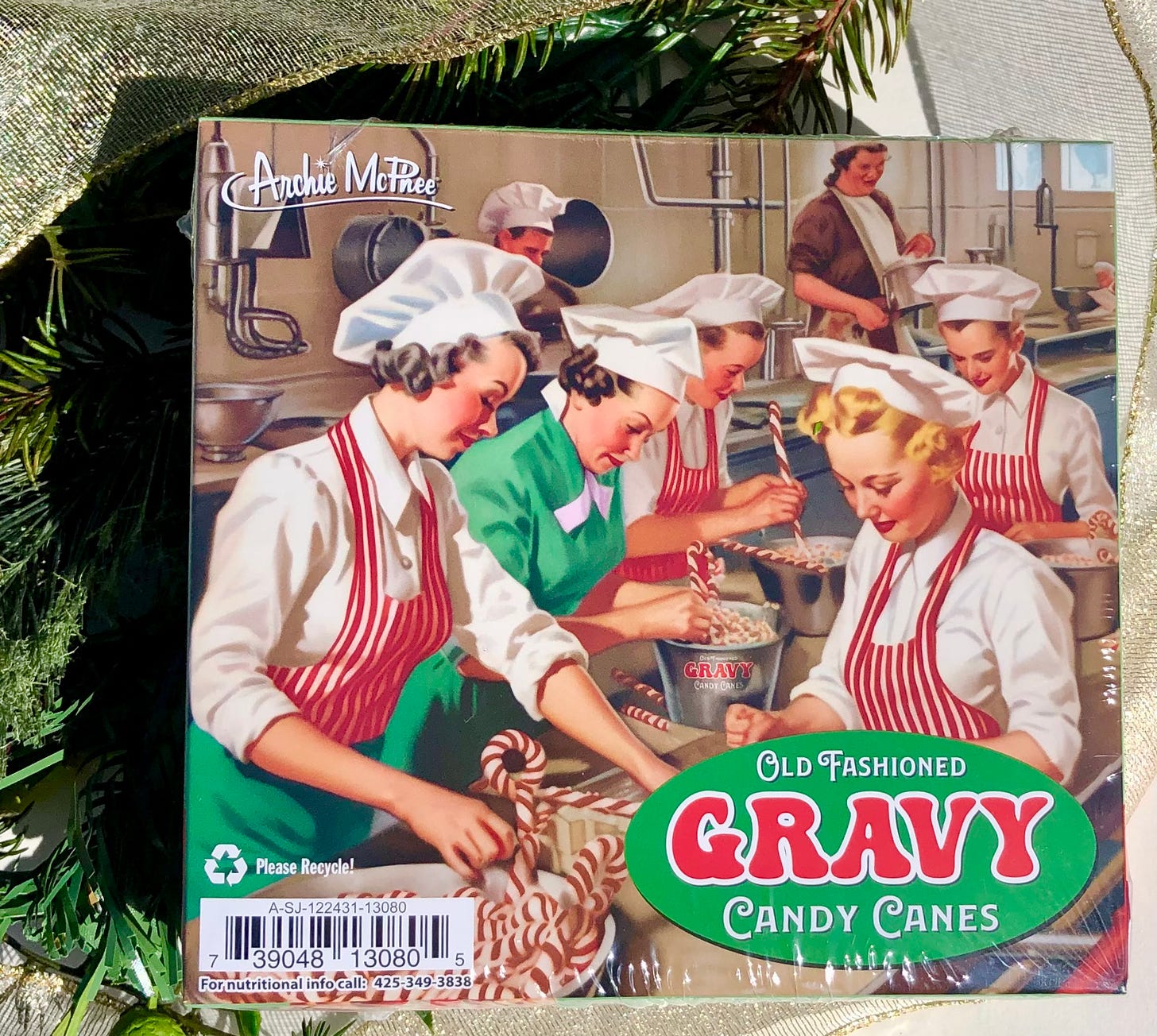 box of Archie McPhee's gravy candy canes with retro painting of women working in a candy factory, labeled "old fashioned gravy candy canes"