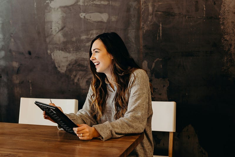 Happy woman sitting at a table.