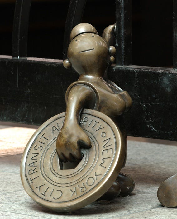 Bronze sculpture by Tom Otherness of a woman with a subway token