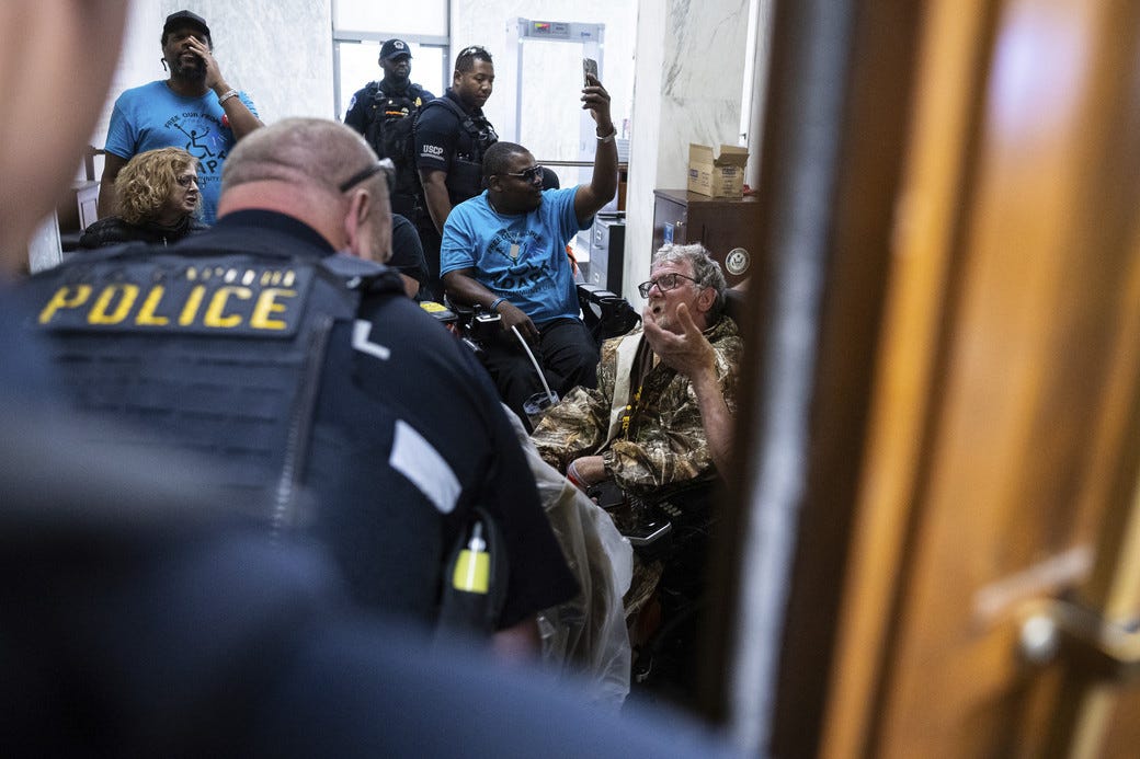 Demonstrators protesting cuts to Medicaid and U.S. Capitol Police officers are seen outside a House Energy and Commerce Committee markup on Capitol Hill, May 13, 2025.