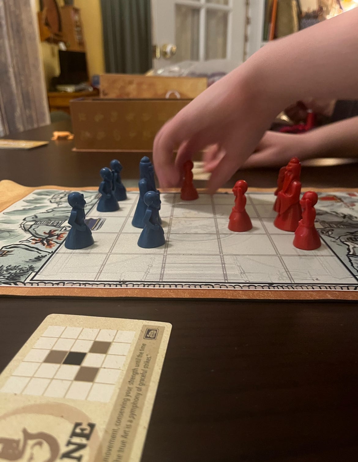 a small board game that looks a bit like chess with red and blue coloured game pieces on a checkered board