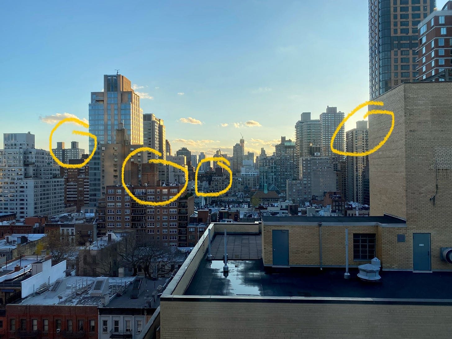 The skyline from an upper floor window. Five stone structures are circled in yellow to highlight that you can just make out the points of the roofs of the water towers they're holding.