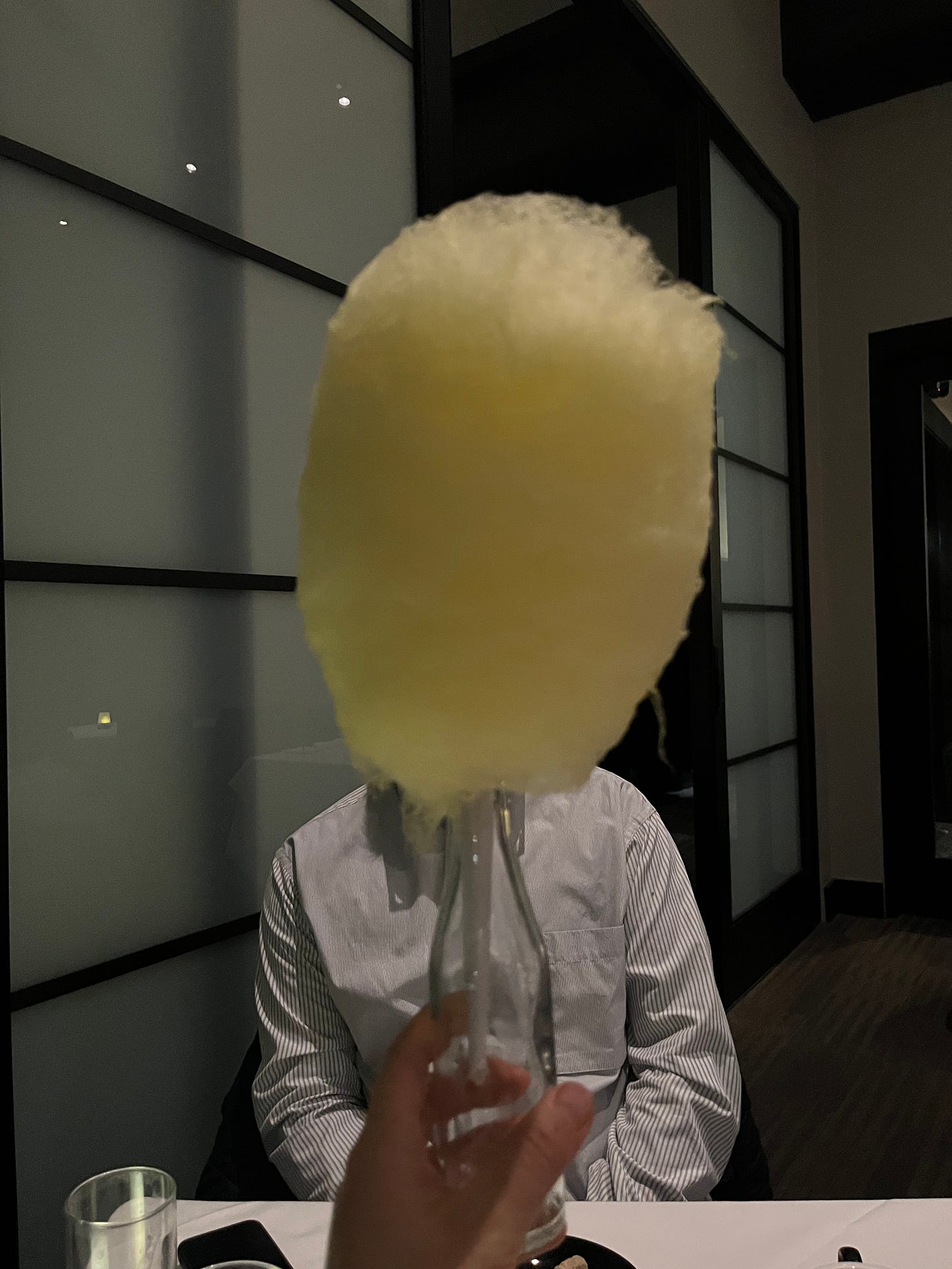 A yellow cotton candy obscuring a man's face.