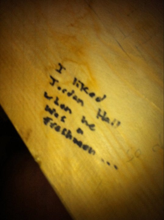 Close-up of a note in permanent marker underneath a table.