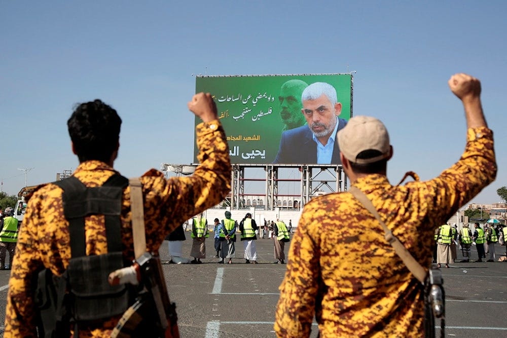 Yemeni soldiers shout slogans in front of a billboard showing martyred Hamas leader Yahya Sinwar during an anti-Israeli rally in Sanaa, Yemen, Friday, October 18, 2024  (AP)