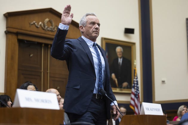 Robert F. Kennedy, Jr. raises his right hand to be sworn in.