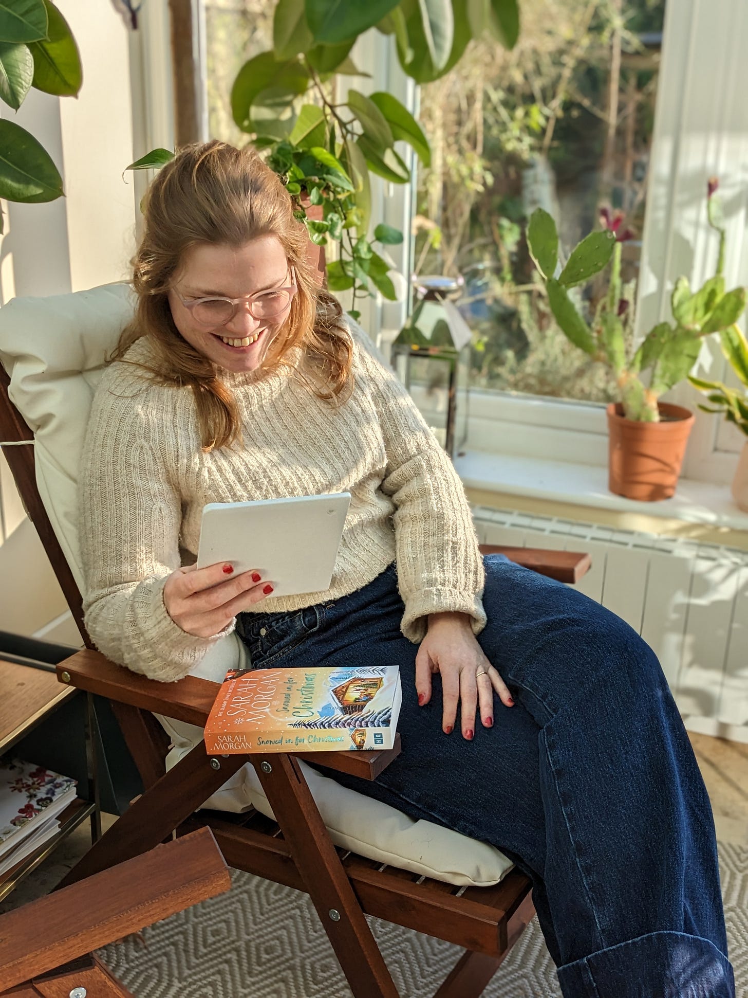 Libby sat in a sunny conservatory reading on an e-reader