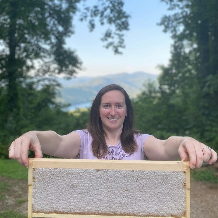 person holding a capped frame of honeycomb